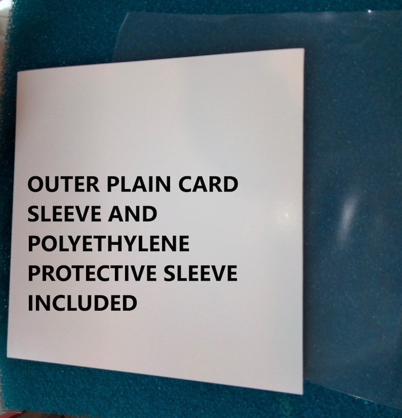 K&ouml;nnte beinhalten: Eine wei&szlig;e Karte mit dem Text "OUTER PLAIN CARD SLEEVE AND POLYETHYLENE PROTECTIVE SLEEVE INCLUDED" wird angezeigt. Eine transparente Plastikh&uuml;lle ist rechts sichtbar. Die Karte liegt auf einer t&uuml;rkisfarbenen Oberfl&auml;che.