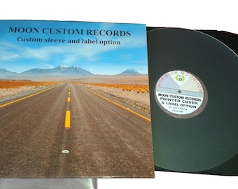 Könnte beinhalten: Eine Schallplatte mit schwarzer Hülle und einem individuellen Etikett mit der Aufschrift NORWICH MOON-ION und MOON CUSTOM RECORDS. Daneben liegt ein quadratisches Plattencover mit einer Wüstenstraßenlandschaft und dem Text MOON CUSTOM RECORDS.