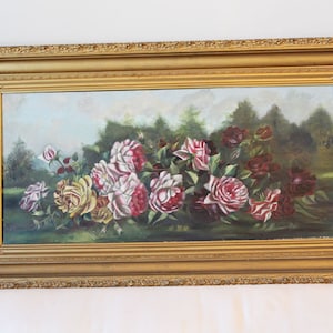 May include: An oil painting of roses in a gold frame. The roses are in shades of red, pink, and yellow, with green foliage and a background of trees. The frame is ornate and rectangular.