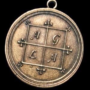 May include: A round, bronze pendant with a square design featuring the letters 'I', 'G', 'L', and 'I' in a grid pattern. The pendant has a loop at the top for hanging.
