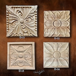Puede incluir: Cuatro tallas decorativas cuadradas de madera con diseños florales y geométricos. Cada talla tiene un diseño diferente, con el texto "D-11", "D-12", "D-13" y "D-14" impreso en cada talla. Las tallas son de color marrón claro.