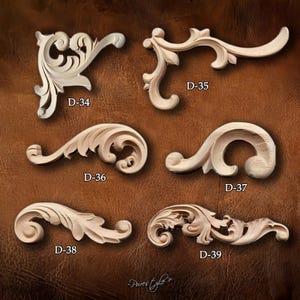 May include: A collection of six unfinished wooden decorative architectural elements, each with a unique carved scroll and leaf design. Each piece is labeled with a "D-" followed by a number. The background is a brown leather-like texture.