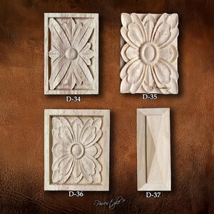 May include: Four unfinished wooden decorative carvings. Three feature floral designs, and one has a geometric pattern. Each carving is rectangular and has the product code "D-34", "D-35", "D-36", and "D-37" printed on it.