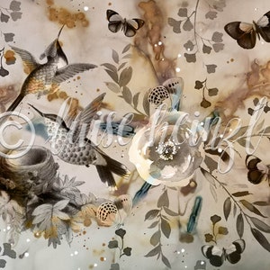 May include: A watercolor painting featuring two hummingbirds in flight, a nest, butterflies, and floral elements. The background is a light brown with brown and blue watercolor splatters.