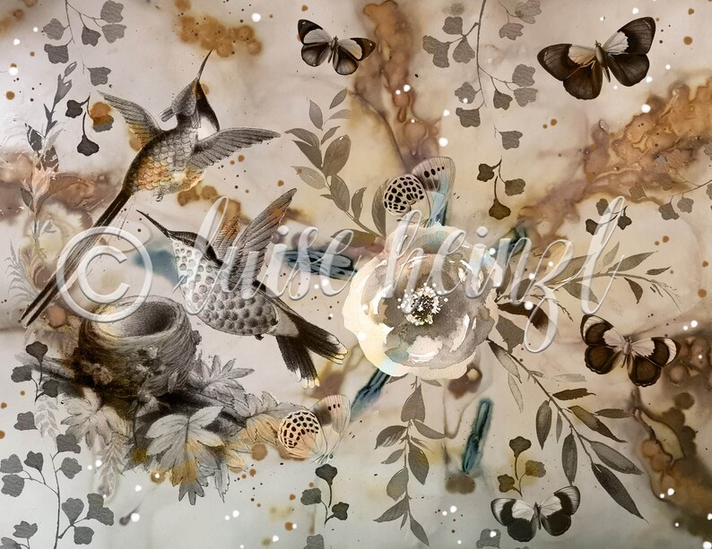 May include: A watercolor painting featuring two hummingbirds in flight, a nest, butterflies, and floral elements. The background is a light brown with brown and blue watercolor splatters.