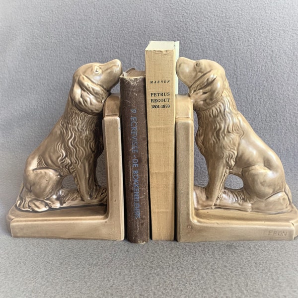 Pair of vintage ceramic bookends with dogs sniffing at the books