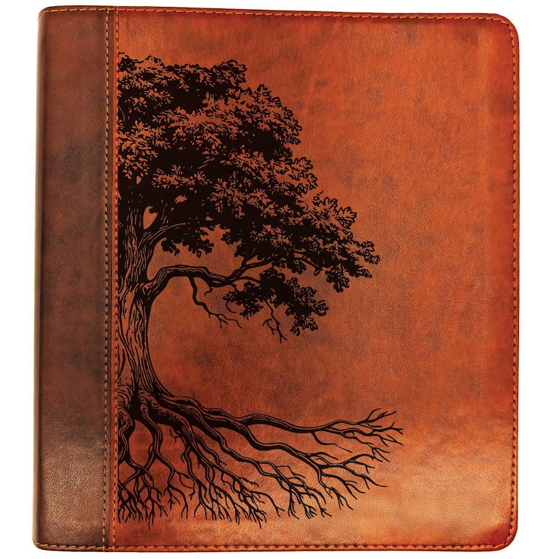 Puede incluir: Un diario de cuero marr&oacute;n con un dise&ntilde;o detallado de un &aacute;rbol negro. Las ra&iacute;ces y ramas del &aacute;rbol est&aacute;n intrincadamente ilustradas en la portada. El diario tiene un borde cosido y un lomo marr&oacute;n m&aacute;s oscuro.
