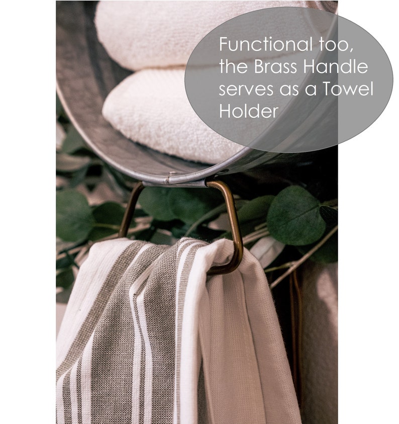 May include: A metal bucket with a brass handle, used as a towel holder. Two white towels are inside the bucket, and a striped towel is hanging from the handle. The text "Functional too, the Brass Handle serves as a Towel Holder" is visible in the image.