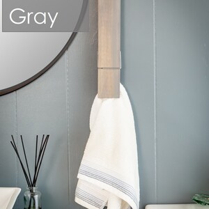 Puede incluir: Una toalla blanca con rayas grises cuelga de un toallero de madera con un clip de metal. El toallero est&aacute; montado en una pared gris. El texto "Classic Gray" es visible en la esquina superior izquierda de la imagen.