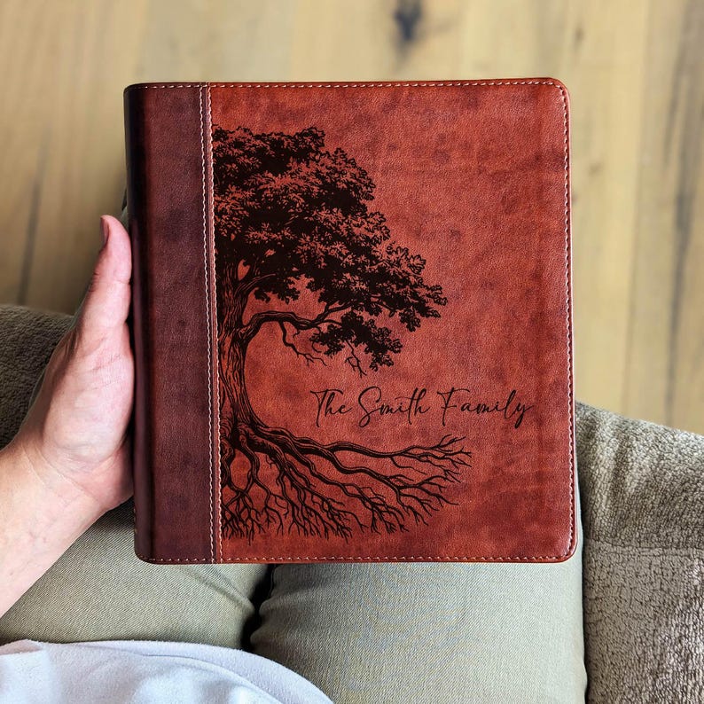 Puede incluir: Un diario de cuero marr&oacute;n con un dise&ntilde;o de &aacute;rbol y el texto "The Smith Family". El diario tiene un lomo marr&oacute;n oscuro. El dise&ntilde;o del &aacute;rbol es marr&oacute;n oscuro.