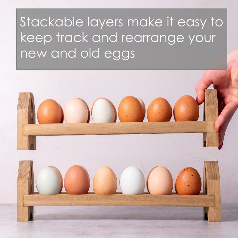 May include: A wooden egg rack with two tiers, each holding ten eggs. The rack is made of natural wood and has a rustic look. The eggs are a mix of brown and white.