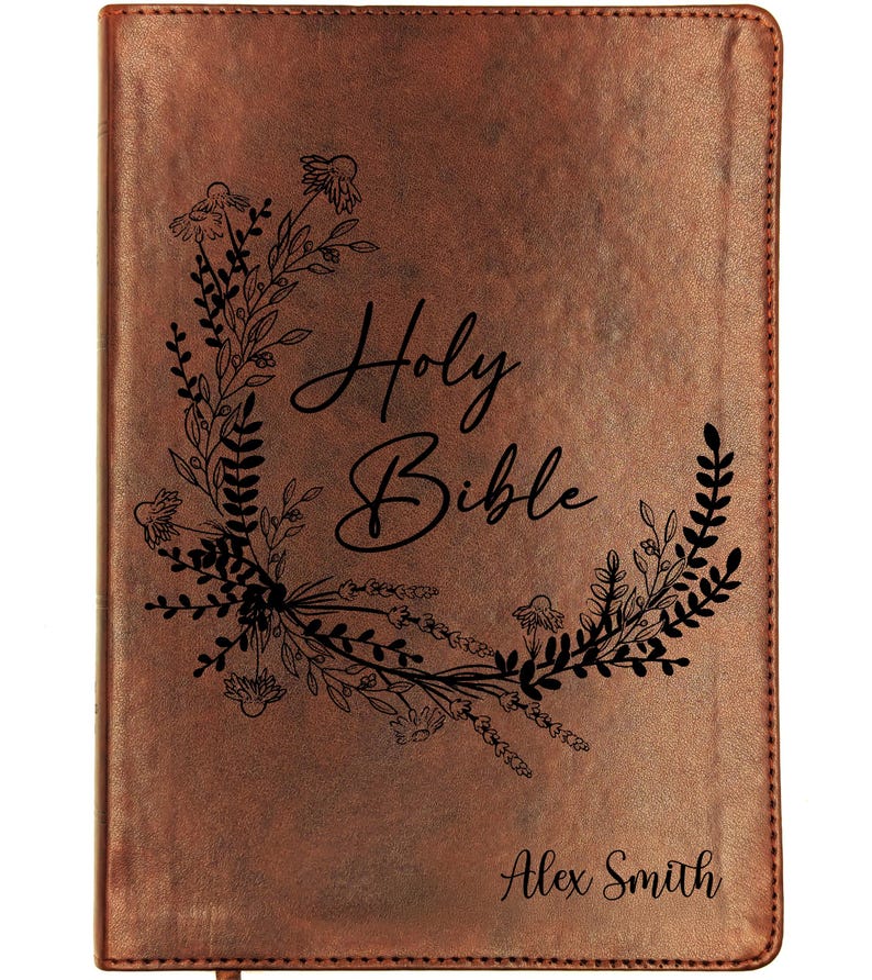 May include: A brown leather-bound Holy Bible. The cover features the words "Holy Bible" in script, framed by a floral wreath. The name "Alex Smith" is printed at the bottom of the cover.