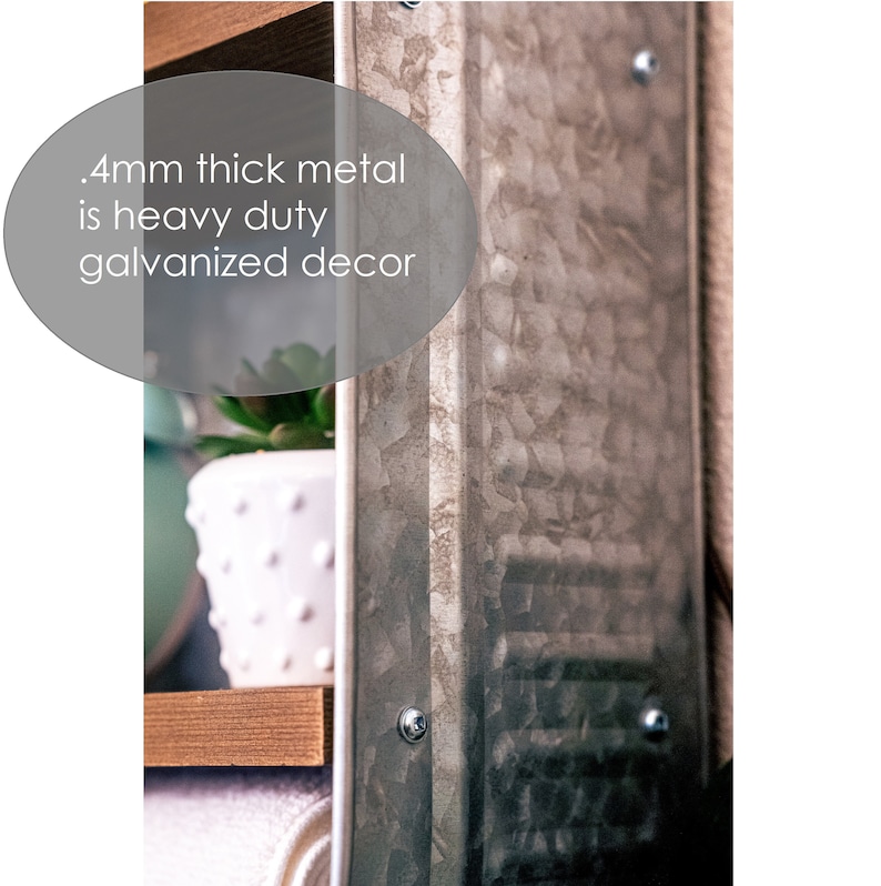May include: Close-up of a galvanised metal shelf unit with a wood top and a white potted succulent plant. The metal is textured and has a hammered finish. The text '.4mm thick metal is heavy duty galvanised decor' is visible in the image.