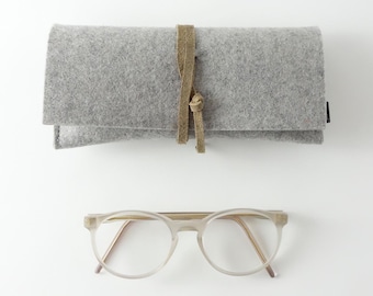 Minimalist glasses case made of pure organic wool felt in light gray with a closure strap made of organic leather in various colors