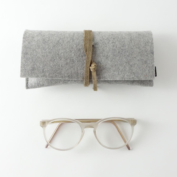 Étui à lunettes minimaliste en feutre de pure laine biologique de couleur gris clair avec une bande de fermeture en cuir biologique de différentes couleurs