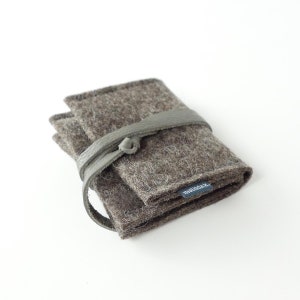 May include: A brown felt wallet with a gray leather strap and a small black label that says "matilda.k."