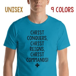 May include: A turquoise blue t-shirt with the text "CHRIST CONQUERS, CHRIST REIGNS, CHRIST COMMANDS!" in black lettering and a black cross.