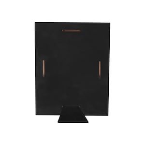 May include: A black wooden picture frame with a built-in easel stand. The back of the frame has a rectangular shape with a horizontal slot and two vertical slots. The easel is a small, black, triangular piece attached to the bottom.
