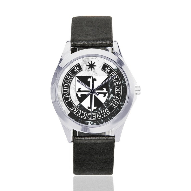May include: A silver wristwatch with a black leather band. The watch face features a black and white emblem with the words "LAUDARE", "BENEDICERE", and "PRAEDICARE" in black text. The watch has a marble-like background.