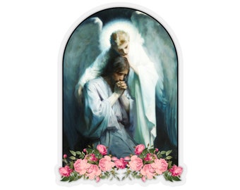 May include: A painting of a man kneeling with his head bowed in prayer, an angel with wings is comforting him. The painting is framed in a white arch and surrounded by pink roses.