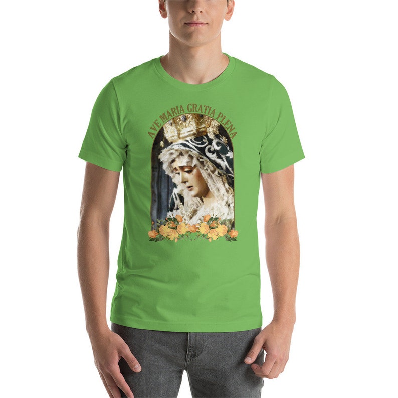 May include: A bright green t-shirt with a religious image of a woman in a crown and veil, framed by yellow roses. The text "AVE MARIA GRATIA PLENA" is arched above the image in gold lettering.