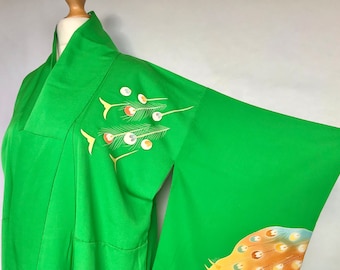 Puede incluir: Un kimono verde con un diseño japonés tradicional de pavos reales y flores. El kimono está hecho de seda y tiene un hermoso brillo.