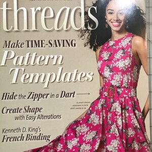 May include: The cover of Threads magazine features a woman in a pink floral dress. The magazine title is in large white letters. Text includes "Make Time-Saving Pattern Templates" and "Hide the Zipper in a Dart".