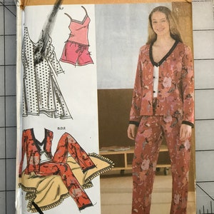 May include: Simplicity sewing pattern #955 featuring sleepwear designs. The pattern includes illustrations of a robe, pajama set, and shorts set. The pajama set is a reddish-brown color with a floral pattern. The pattern is for sizes HH 6, 8, 10, and 12.