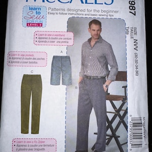 May include: McCall's sewing pattern M7987 for pants. The pattern includes instructions for a waistband, pockets, and a fly zipper. The package features a photo of a man wearing a shirt and pants, with size information in the upper right corner.