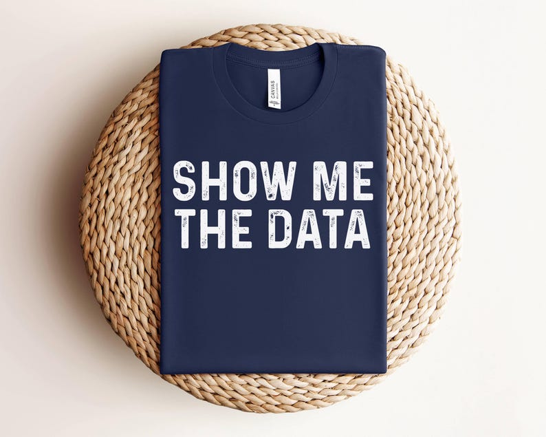 May include: A navy blue t-shirt with the text "Show Me The Data" in white lettering.