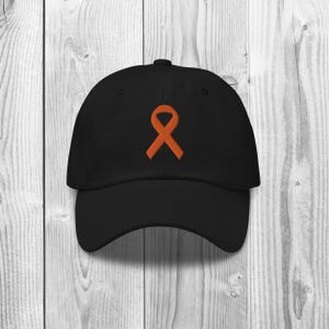 May include: A black baseball cap with an orange ribbon embroidered on the front.