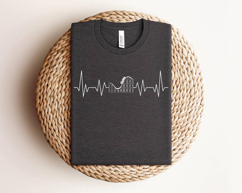 May include: Dark gray t-shirt with a white graphic of a roller coaster inside a heartbeat. The graphic is a simple line drawing.