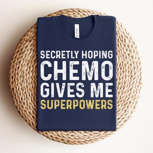 May include: A navy blue t-shirt with white text that reads "Secretly Hoping Chemo Gives Me Superpowers".