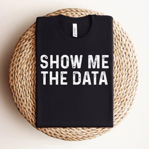 May include: Black t-shirt with white text that reads "Show Me The Data".
