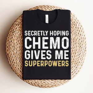 May include: Black t-shirt with white text that reads "Secretly hoping chemo gives me superpowers".
