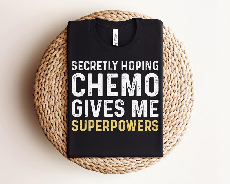 May include: Black t-shirt with white text that reads "Secretly hoping chemo gives me superpowers".