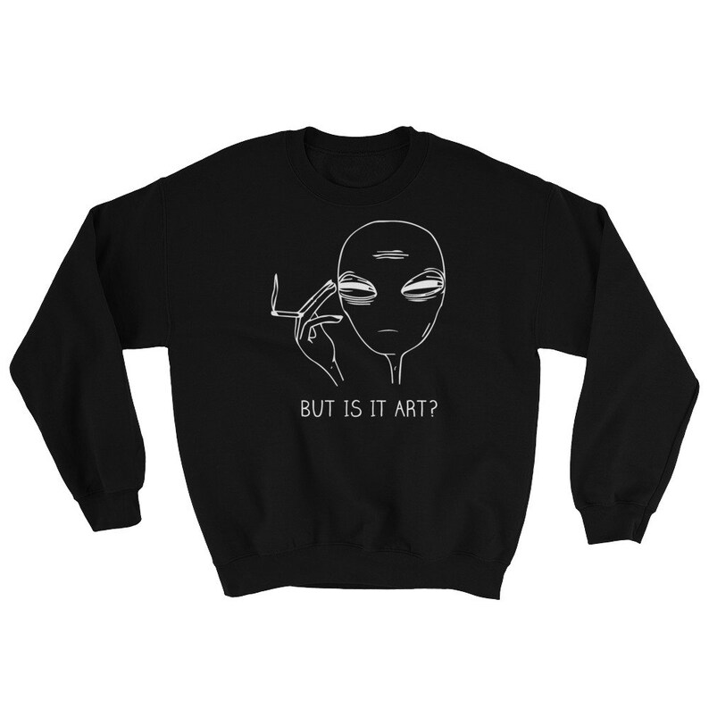 May include: Black sweatshirt featuring a white outline of an alien smoking a cigarette with the text "BUT IS IT ART?"