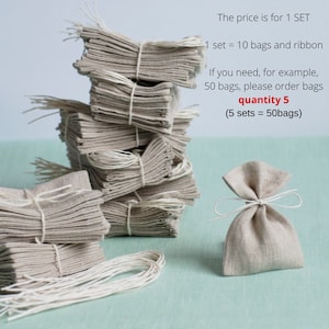 May include: A stack of 10 small, natural linen drawstring bags with white twine. The bags are tied together with white twine. A single bag is shown in the foreground. The price is for 1 set, which includes 10 bags and ribbon.  The text "The price is for 1 SET 1 set = 10 bags and ribbon If you need, for example, 50 bags, please order bags quantity 5 (5 sets = 50bags)" is written in red text.