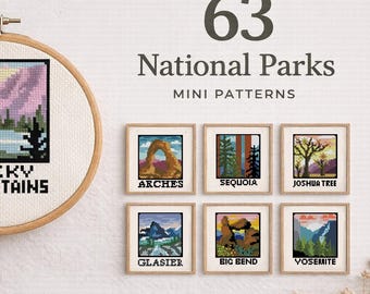 May include: A cross-stitch pattern featuring a landscape of the Rocky Mountains, displayed in a wooden embroidery hoop. The image also shows six framed mini patterns of national parks, including Arches, Sequoia, and Joshua Tree. The text reads "63 National Parks Mini Patterns."