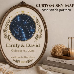 Peut inclure: Broderie personnalisée d'une carte du ciel dans un cadre ovale. Le motif présente une carte céleste bleu foncé avec des constellations, entourée d'une bordure beige et d'éléments floraux. Les noms "Emily & David" et la date "October 15, 2026" sont brodés.
