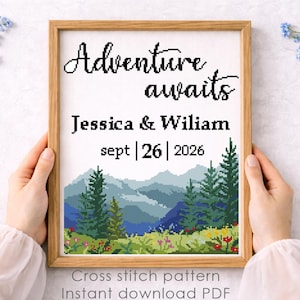May include: A framed cross-stitch pattern with the words "Adventure awaits" above the names Jessica & Wiliam and the date Sept 26, 2026. The design features a mountain landscape with trees and flowers. Text at the bottom reads "Cross stitch pattern Instant download PDF."