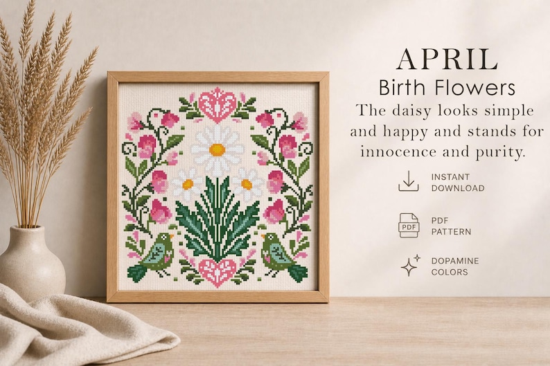 May include: A framed cross-stitch design featuring a floral pattern with pink flowers, green leaves, and two green birds. The text "APRIL Birth Flowers" is displayed above the design. The daisy looks simple and happy and stands for innocence and purity.