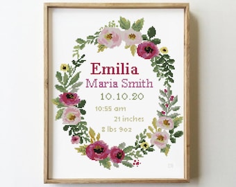 Puede incluir: Anuncio de nacimiento bordado a punto de cruz enmarcado, con el nombre "Emilia Maria Smith" y detalles de nacimiento. El diseño incluye una corona floral en rosa, verde y amarillo. La longitud del bebé es de 53 cm y el peso es de 4,05 kg.