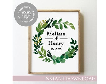 Puede incluir: Patrón de punto de cruz con una corona de hojas verdes sobre fondo blanco. La corona tiene una pancarta negra con el texto "Melissa & Henry 10.10.20".