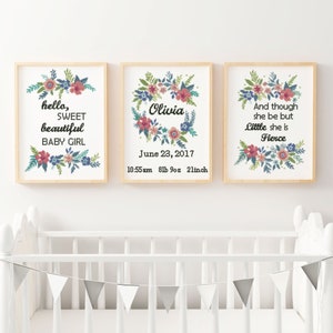 May include: Three framed prints with floral designs and text. The first print says "hello, sweet beautiful baby girl". The second print says "Olivia" with the date "June 23, 2017" and the time "10:55 am 8lb 9oz 2linch". The third print says "And though she be but little she is fierce".