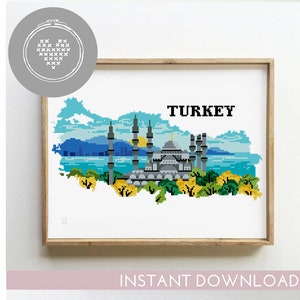 May include: A cross-stitch pattern of Turkey with a mosque and minarets in the center, surrounded by a blue sky and green trees. The pattern is in the shape of Turkey's outline. The text "TURKEY" is above the pattern.