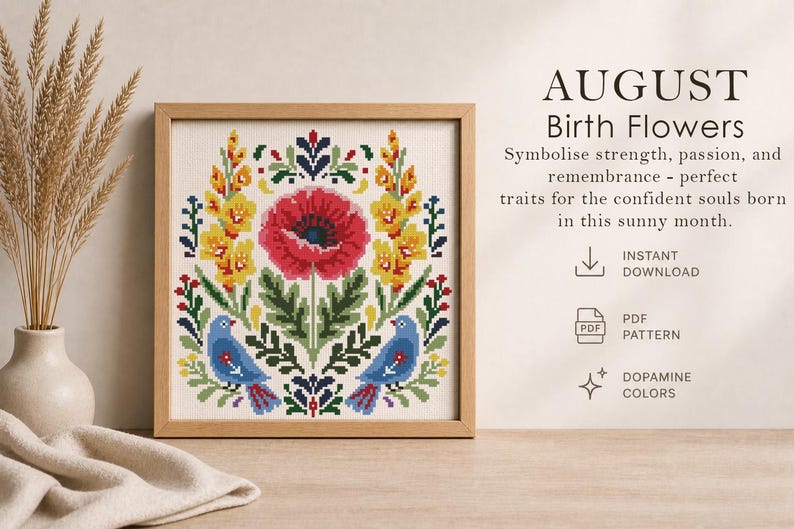 May include: A framed cross-stitch design featuring a central red poppy, surrounded by yellow and green floral elements, and two blue birds. The text "AUGUST Birth Flowers" is displayed above the design. The design is in a wooden frame.