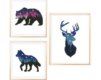 May include: Three framed prints with silhouettes of a bear, a deer, and a wolf. Each silhouette is filled with a starry night sky and a forest scene.
