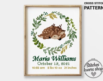 May include: Cross stitch pattern featuring a sleeping fawn surrounded by a green and gold leafy wreath. The pattern includes the text "Maria Williams, October 15, 2021, 10:55 am 8 lbs 10 oz 21 inches".
