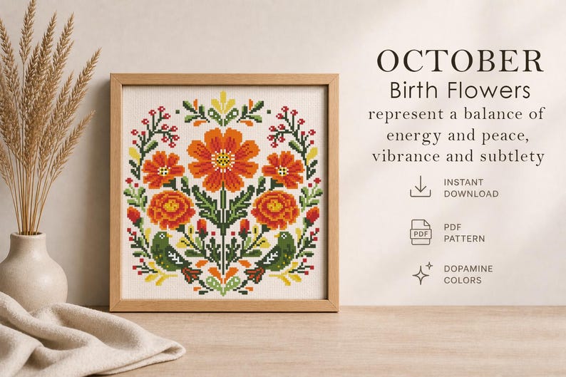 May include: A framed cross-stitch pattern featuring October birth flowers in vibrant orange, red, green, and yellow. The design includes floral elements and the text "OCTOBER Birth Flowers". The artwork is displayed with dried wheat in a vase.
